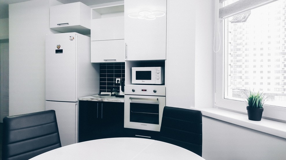 Example of a danish kitchen design in Moscow with an undermount sink, black backsplash and white countertops