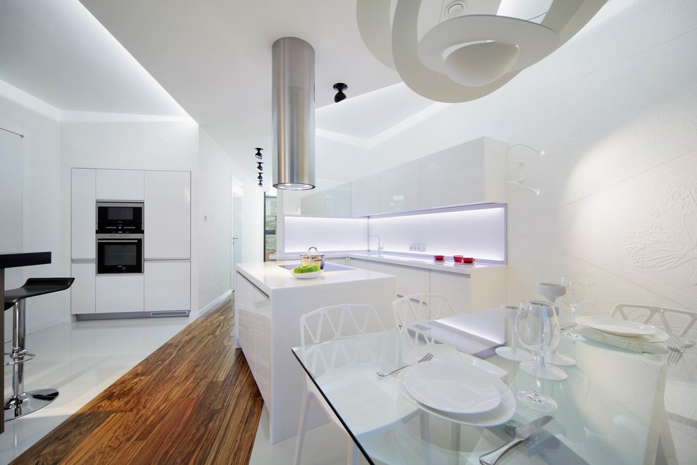 Große Moderne Wohnküche mit flächenbündigen Schrankfronten, weißen Schränken, Küchenrückwand in Weiß, Kücheninsel, weißen Elektrogeräten und braunem Holzboden in Jekaterinburg