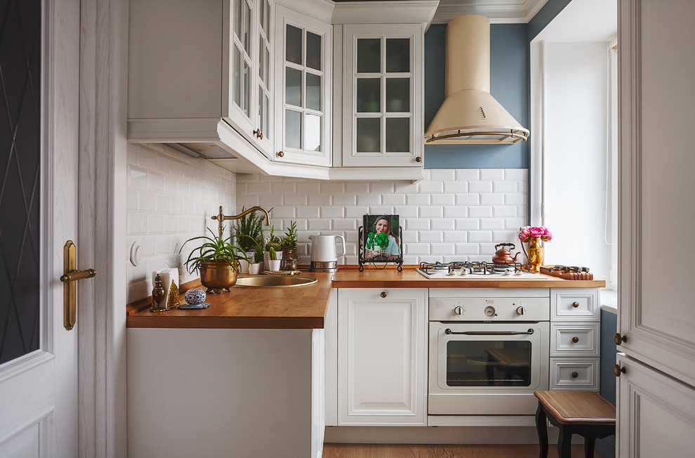 Design ideas for a small rural l-shaped kitchen in Moscow with a built-in sink, glass-front cabinets, white cabinets, wood worktops, white splashback, metro tiled splashback, white appliances, medium hardwood flooring and no island.