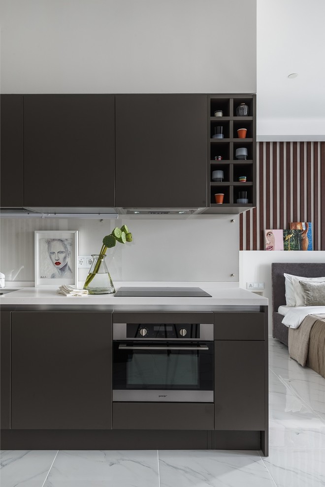 Photo of a contemporary single-wall open plan kitchen in Moscow with flat-panel cabinets, grey cabinets, white splashback, glass sheet splashback, stainless steel appliances, marble flooring, no island and white floors.