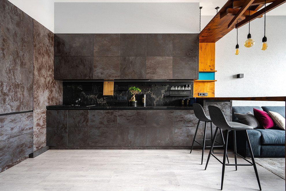 Idéer för att renovera ett stort funkis svart svart kök, med marmorbänkskiva, svart stänkskydd, stänkskydd i marmor, laminatgolv, grått golv, släta luckor, grå skåp och en halv köksö