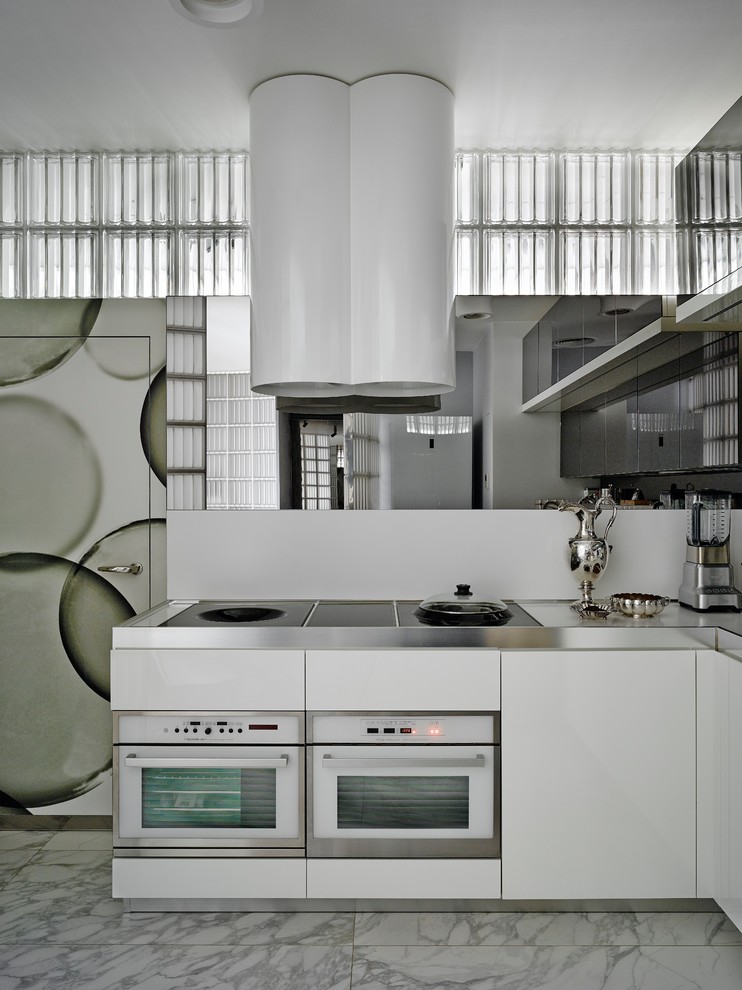 Idéer för funkis grått kök, med släta luckor, vita skåp, bänkskiva i rostfritt stål, vitt stänkskydd, vita vitvaror, grått golv och spegel som stänkskydd