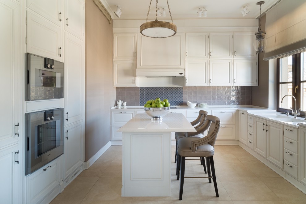 This is an example of a traditional l-shaped kitchen in Moscow with raised-panel cabinets, white cabinets, grey splashback, an island, a double-bowl sink and stainless steel appliances.