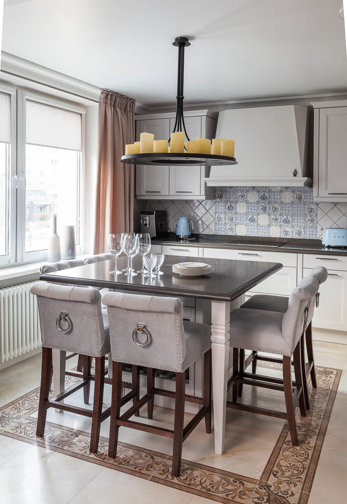 Klassische Küche mit Schrankfronten mit vertiefter Füllung, grauen Schränken, bunter Rückwand und Kücheninsel in Sonstige
