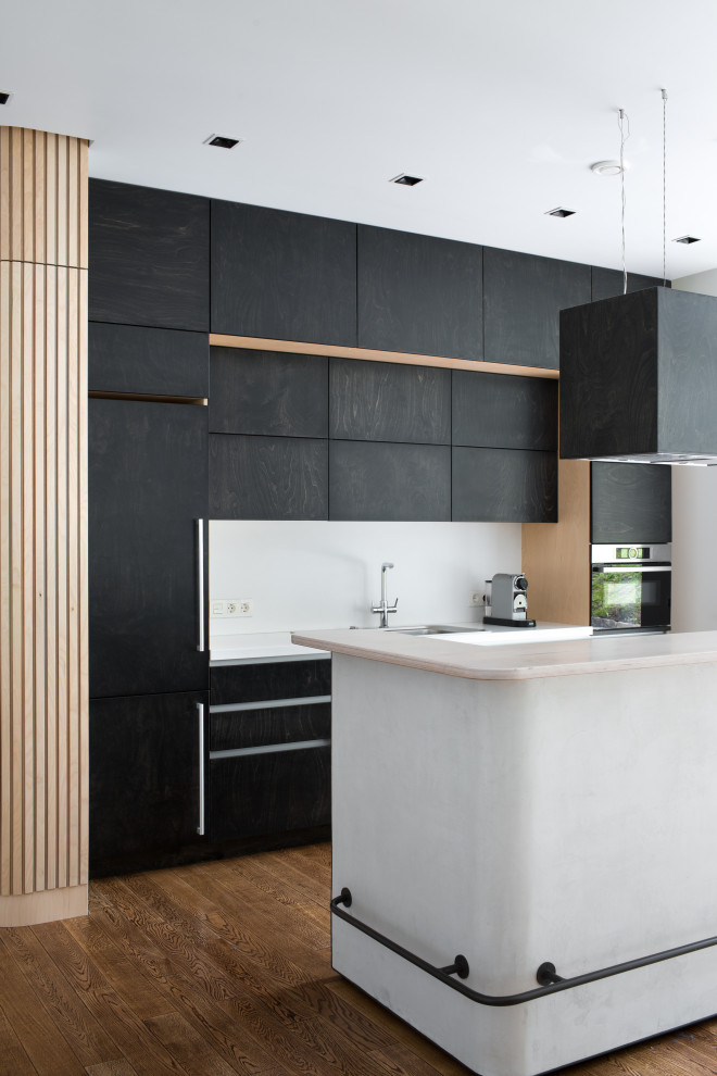 Foto di una cucina contemporanea con ante lisce, ante nere, elettrodomestici neri, parquet scuro, pavimento marrone e top bianco