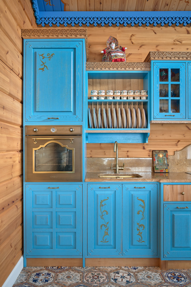 Idées déco pour une cuisine campagne avec un évier encastré, un placard avec porte à panneau surélevé, des portes de placard bleues, un sol multicolore et un plan de travail beige.