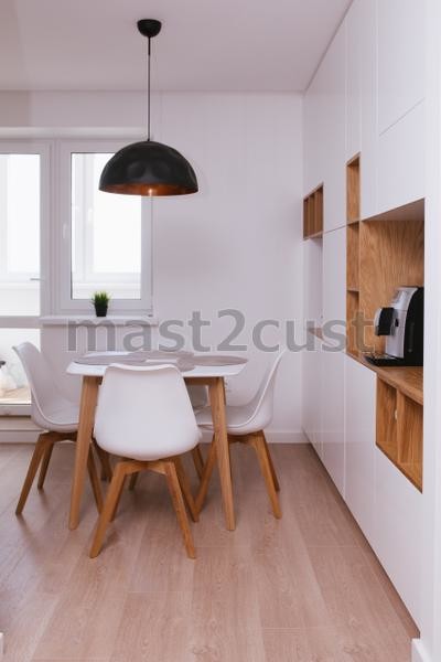 Moderne Wohnküche mit weißen Schränken, Arbeitsplatte aus Holz, hellem Holzboden und beigem Boden