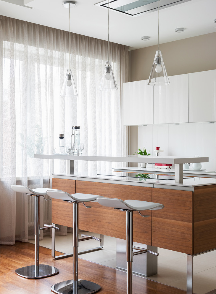 Foto di un cucina con isola centrale contemporaneo con ante lisce, paraspruzzi bianco, top bianco, pavimento beige e parquet e piastrelle