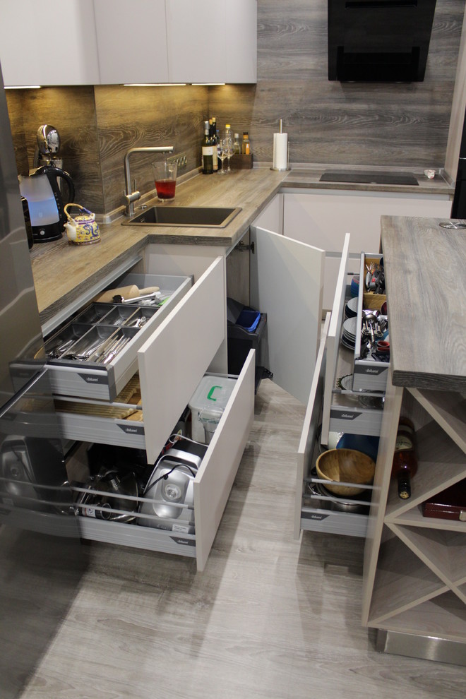 Foto di una grande cucina contemporanea con lavello sottopiano, ante lisce, ante bianche, paraspruzzi marrone, pavimento in laminato, pavimento beige e top marrone