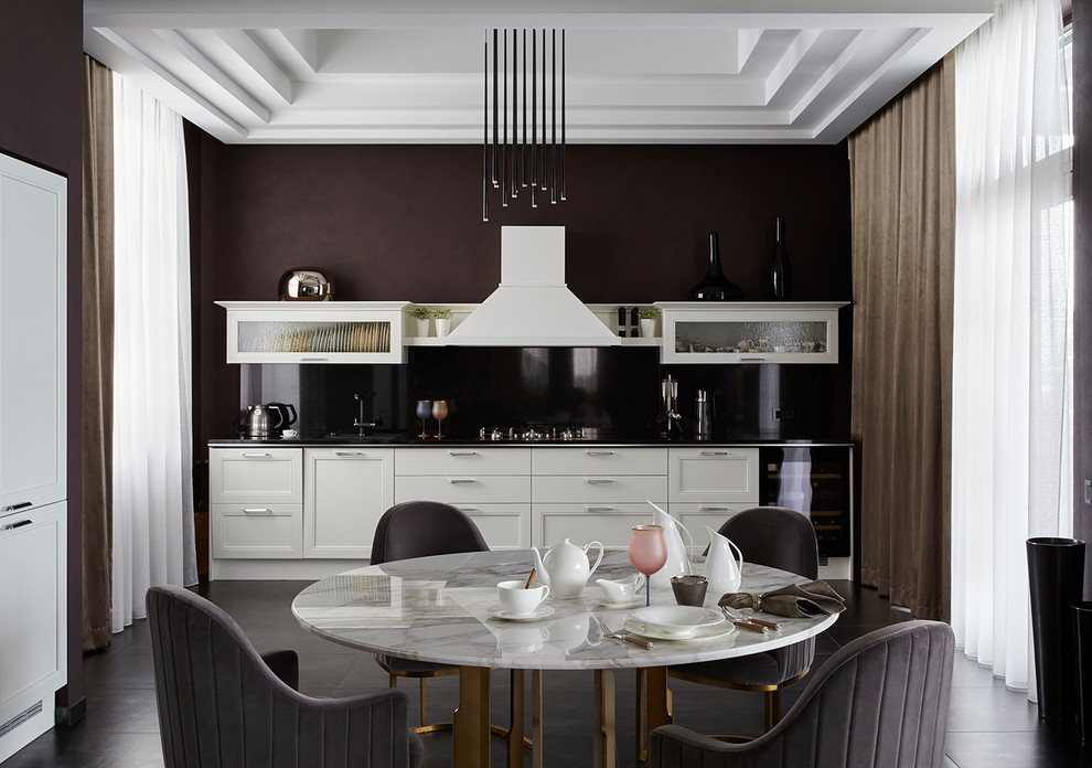 Modern inredning av ett mellanstort linjärt kök och matrum, med en undermonterad diskho, vita skåp, granitbänkskiva, svart stänkskydd, klinkergolv i porslin, grått golv och luckor med infälld panel