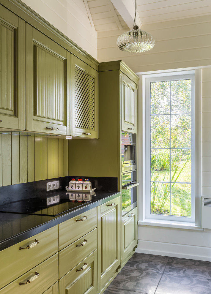Photo of a small classic single-wall kitchen in Moscow with green cabinets, marble worktops, black appliances, ceramic flooring, raised-panel cabinets, green splashback, wood splashback and multi-coloured floors.