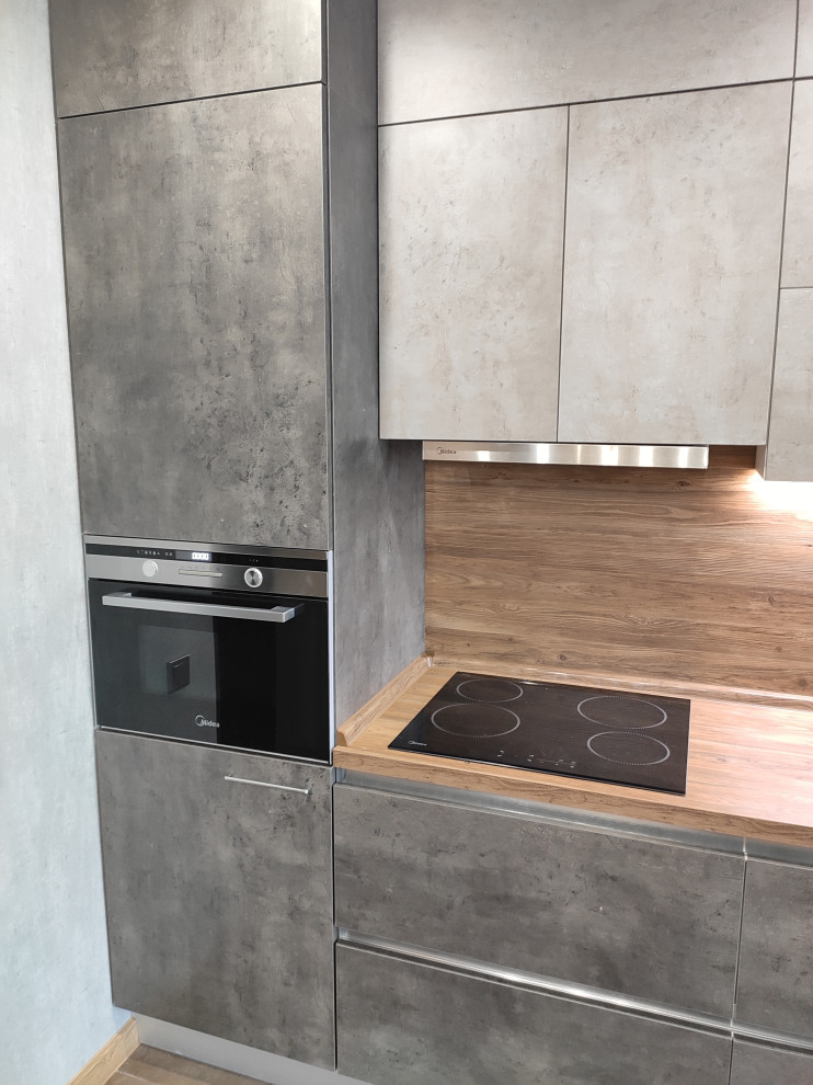 Photo of a small contemporary single-wall enclosed kitchen in Other with a built-in sink, flat-panel cabinets, grey cabinets, laminate countertops, wood splashback, stainless steel appliances and no island.