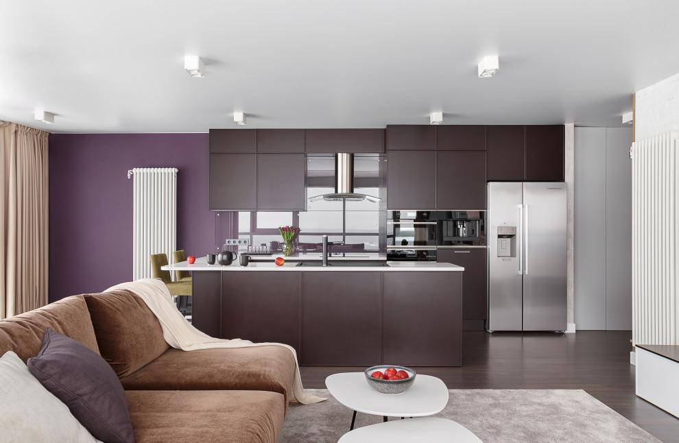 This is an example of a large contemporary galley open plan kitchen in Other with a built-in sink, flat-panel cabinets, brown cabinets, glass sheet splashback, stainless steel appliances, an island, brown floors and white worktops.
