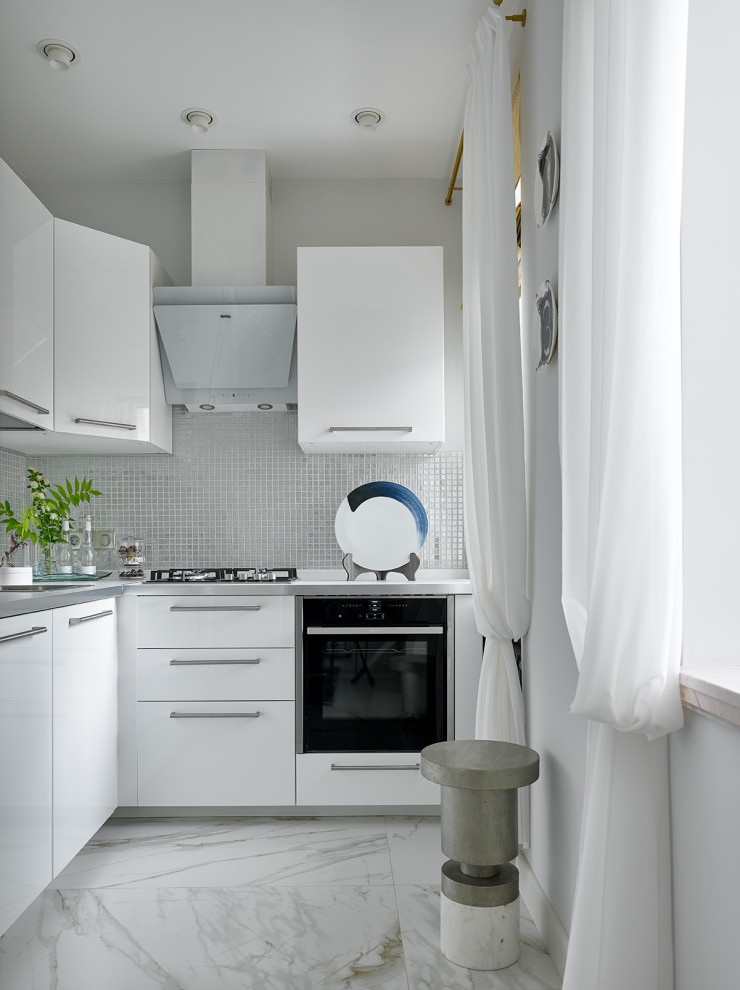 Свежая идея для дизайна: маленькая угловая кухня в современном стиле с плоскими фасадами и белыми фасадами для на участке и в саду - отличное фото интерьера
