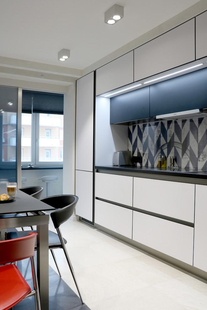 Immagine di una cucina design chiusa con ante lisce, ante bianche, paraspruzzi grigio, nessuna isola e pavimento beige