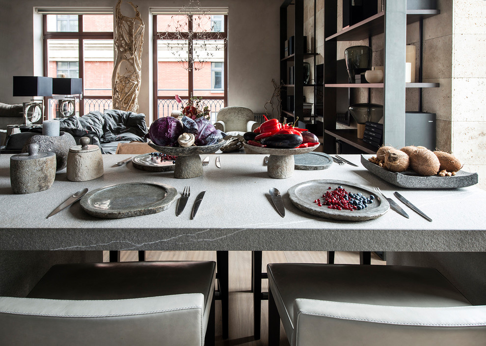 Foto på ett funkis kök, med en integrerad diskho, släta luckor, grå skåp, grått stänkskydd, stänkskydd i sten, en köksö, beiget golv, granitbänkskiva, rostfria vitvaror och ljust trägolv