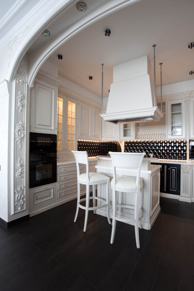 Foto de cocina clásica con salpicadero negro, electrodomésticos negros, una isla y con blanco y negro