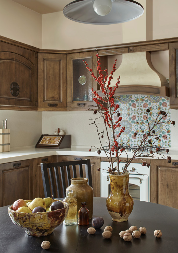 Kitchen - mid-sized country galley ceramic tile and beige floor kitchen idea in Moscow with raised-panel cabinets, medium tone wood cabinets, white backsplash, white appliances, no island, an integrated sink, solid surface countertops and stone slab backsplash