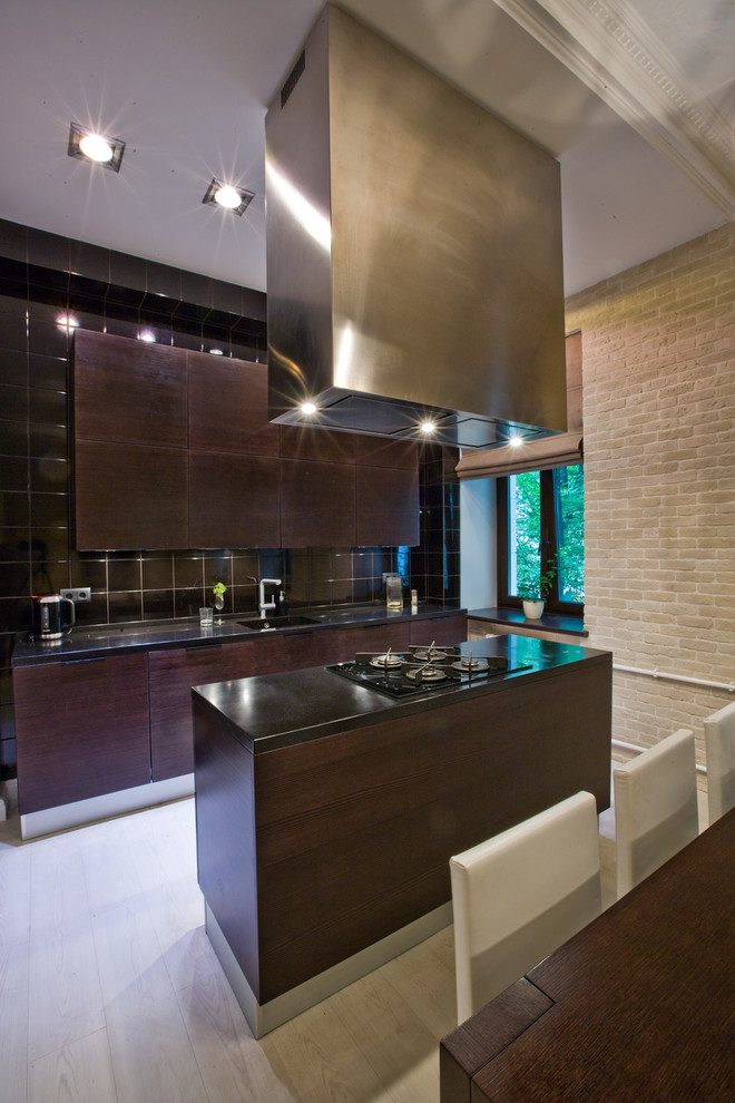 Esempio di una cucina design di medie dimensioni con lavello sottopiano, ante in legno bruno, top in superficie solida, paraspruzzi nero, paraspruzzi con piastrelle in ceramica, elettrodomestici neri e pavimento in laminato