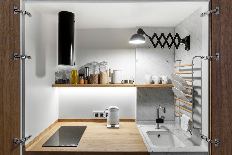 На фото: маленькая отдельная кухня в современном стиле с врезной мойкой, мраморной столешницей и белым фартуком для на участке и в саду с