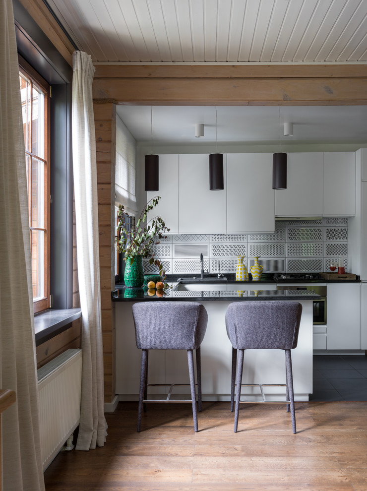 Modern inredning av ett mellanstort kök, med en nedsänkt diskho, släta luckor, vita skåp, granitbänkskiva, flerfärgad stänkskydd, stänkskydd i keramik, rostfria vitvaror, en halv köksö, svart golv och mellanmörkt trägolv