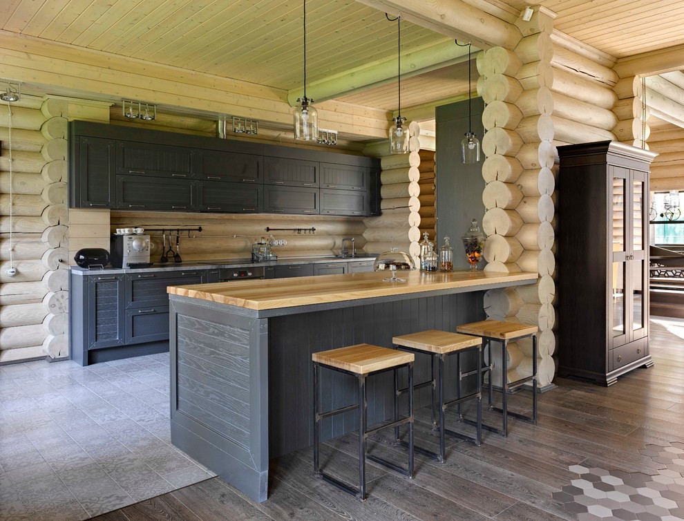 Foto de cocina campestre con armarios con paneles empotrados, puertas de armario negras, salpicadero beige, una isla y suelo gris