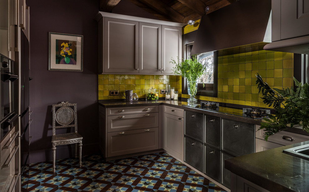 На фото: п-образная кухня в классическом стиле с накладной мойкой, фасадами с утопленной филенкой, серыми фасадами, желтым фартуком и разноцветным полом без острова с