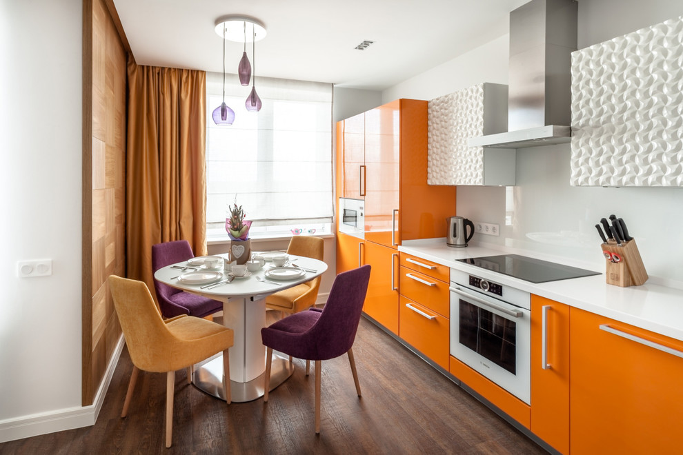 Inredning av ett modernt litet linjärt kök och matrum, med vitt stänkskydd, glaspanel som stänkskydd, vita vitvaror, vinylgolv, brunt golv, släta luckor och orange skåp