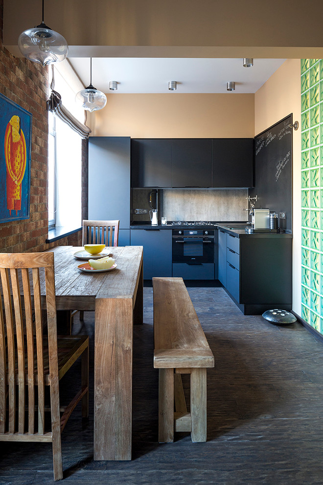 Imagen de cocinas en L bohemia de tamaño medio abierta sin isla con armarios con paneles lisos, puertas de armario negras y electrodomésticos negros