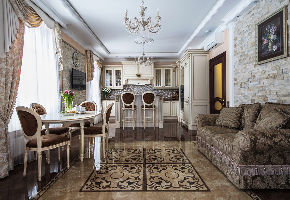 Свежая идея для дизайна: угловая кухня-гостиная в классическом стиле с бежевыми фасадами, коричневым фартуком, островом и коричневым полом - отличное фото интерьера