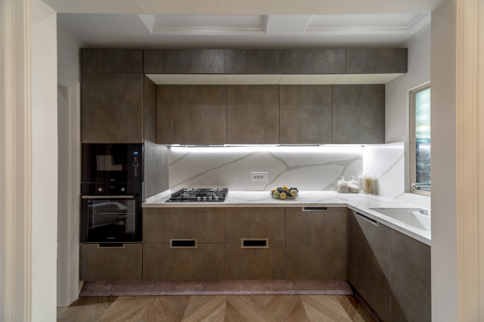 Foto på ett avskilt, mellanstort funkis grå l-kök, med släta luckor, grå skåp, grått stänkskydd, integrerade vitvaror och brunt golv