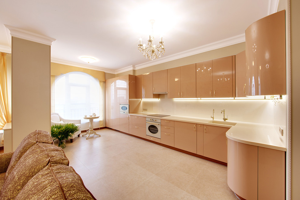 This is an example of a contemporary kitchen in Moscow with beige cabinets, composite countertops, beige splashback, glass sheet splashback and white appliances.