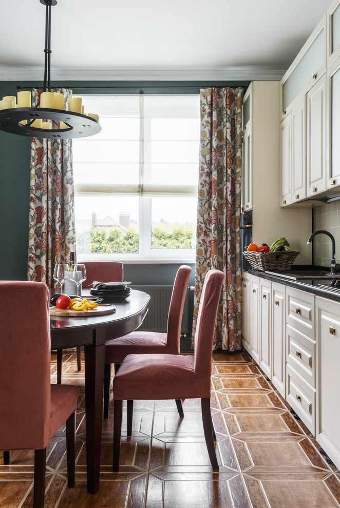 Diseño de cocina clásica renovada con armarios con paneles con relieve, puertas de armario blancas, fregadero encastrado y suelo marrón