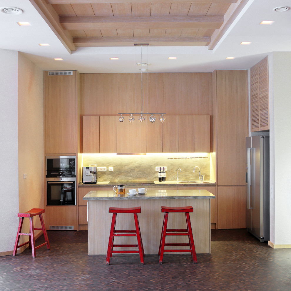 This is an example of a contemporary galley kitchen in Moscow with flat-panel cabinets, light wood cabinets, stone slab splashback, stainless steel appliances and an island.