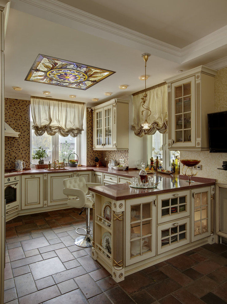 Immagine di una cucina tradizionale chiusa e di medie dimensioni con lavello integrato, ante con bugna sagomata, ante beige, top in superficie solida, paraspruzzi beige, paraspruzzi con piastrelle a mosaico, elettrodomestici colorati, pavimento in terracotta, pavimento multicolore e top marrone