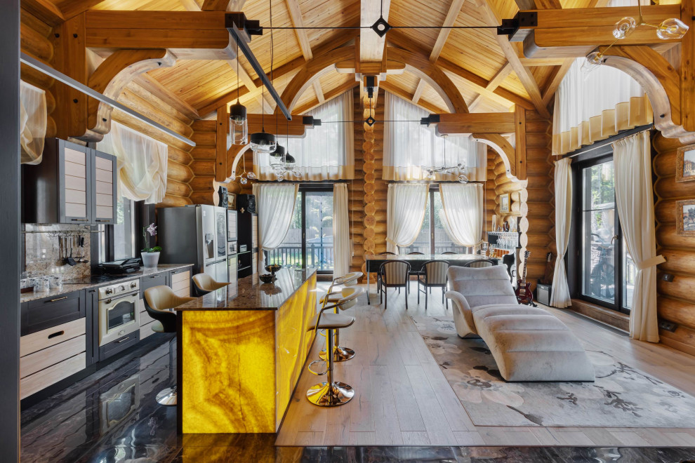 На фото: кухня-гостиная в стиле рустика с фасадами в стиле шейкер, черными фасадами, цветной техникой, островом, бежевой столешницей, балками на потолке, сводчатым потолком и деревянным потолком с