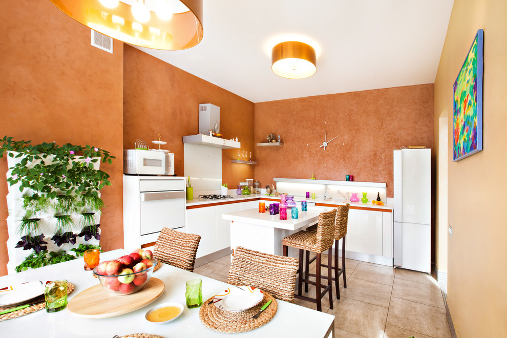 Идея дизайна: маленькая угловая кухня в средиземноморском стиле с обеденным столом, одинарной мойкой, плоскими фасадами, белыми фасадами, оранжевым фартуком, полом из терракотовой плитки и островом для на участке и в саду