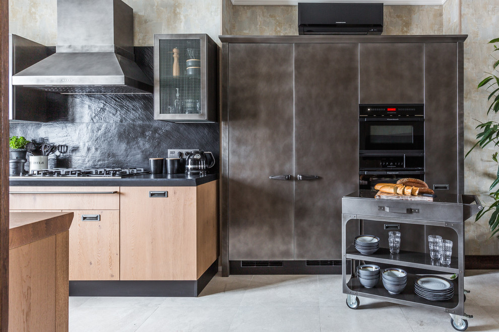 Zweizeilige Industrial Küche mit flächenbündigen Schrankfronten, Küchenrückwand in Schwarz, grauen Schränken, schwarzen Elektrogeräten und grauem Boden in Sonstige