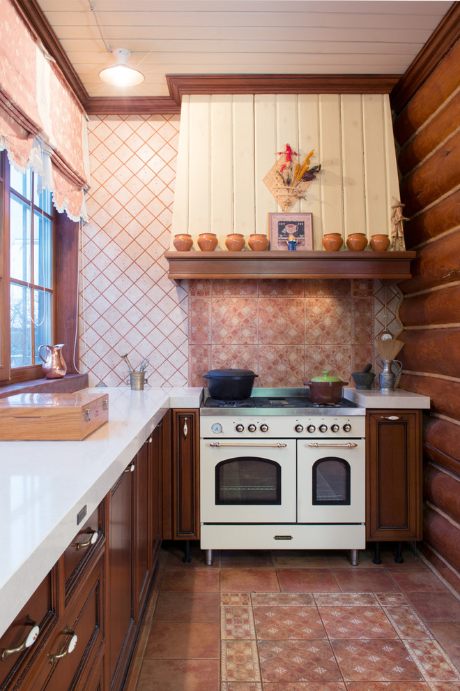 Стильный дизайн: угловая кухня в стиле рустика с фасадами с утопленной филенкой, темными деревянными фасадами, разноцветным фартуком, белой техникой, разноцветным полом, белой столешницей и красивой плиткой - последний тренд