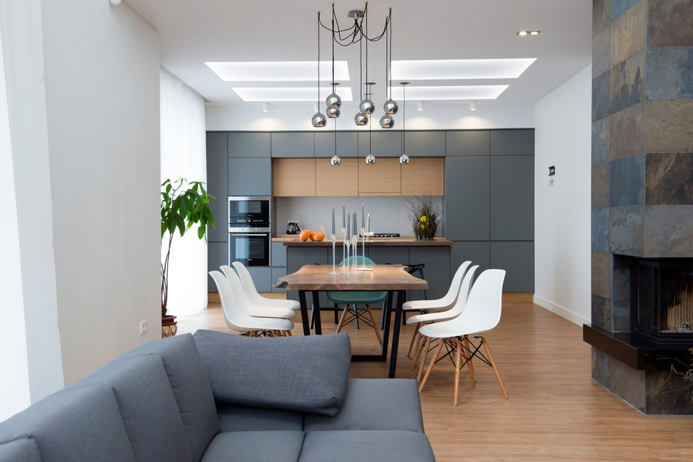 Свежая идея для дизайна: прямая кухня в современном стиле с плоскими фасадами, серыми фасадами и коричневым полом - отличное фото интерьера
