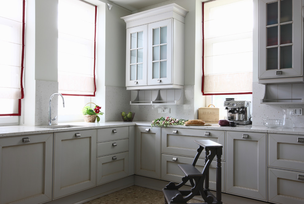 Exemple d'une cuisine tendance avec un évier encastré, un placard avec porte à panneau encastré, des portes de placard blanches et une crédence blanche.