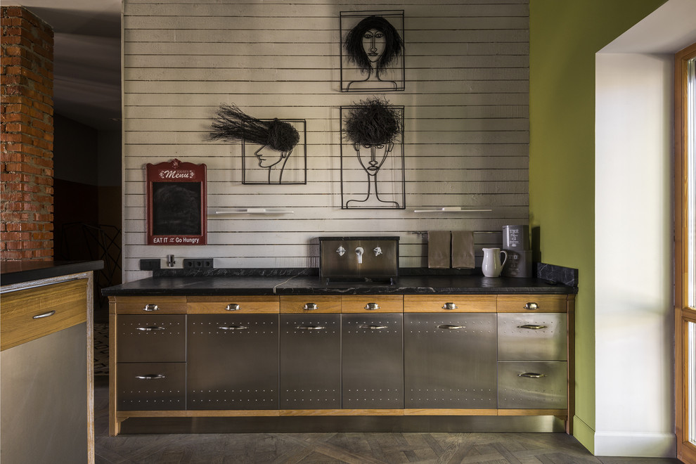 Esempio di una cucina industriale con ante lisce, ante in acciaio inossidabile, paraspruzzi bianco, paraspruzzi in legno, top nero e pavimento grigio