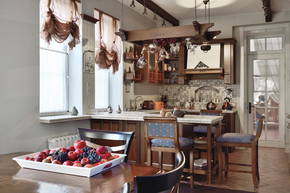 Immagine di una cucina country con top piastrellato, penisola, pavimento marrone, top bianco, ante in legno bruno, paraspruzzi multicolore e paraspruzzi con piastrelle a mosaico