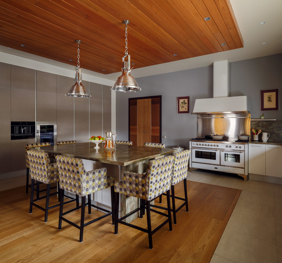 Foto de cocina comedor actual con armarios con paneles lisos, electrodomésticos blancos, una isla, salpicadero metalizado, suelo de madera en tonos medios y puertas de armario blancas