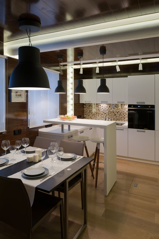 Design ideas for a medium sized contemporary u-shaped kitchen/diner in Moscow with a built-in sink, flat-panel cabinets, white cabinets, composite countertops, glass sheet splashback, black appliances, light hardwood flooring and no island.