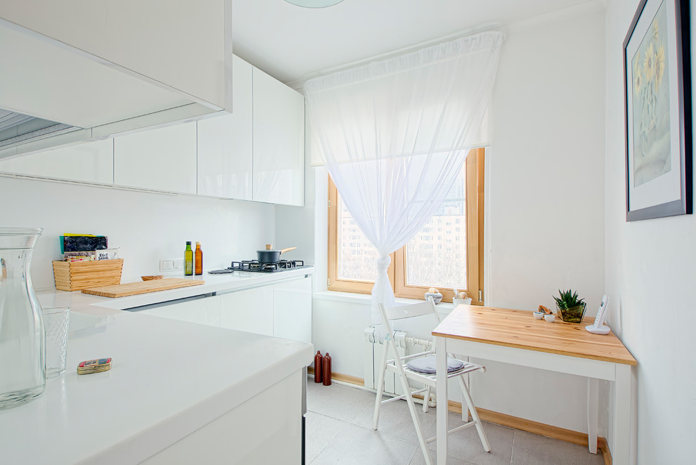 Idéer för avskilda, små skandinaviska l-kök, med en integrerad diskho, släta luckor, vita skåp, bänkskiva i koppar, vitt stänkskydd, integrerade vitvaror, klinkergolv i porslin och grått golv