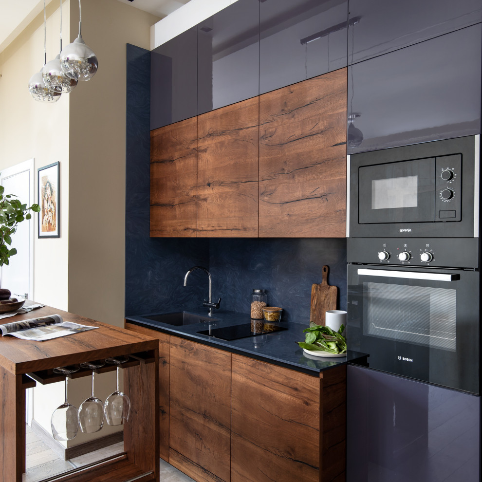 Inredning av ett mellanstort blå linjärt blått kök och matrum, med en enkel diskho, grå skåp, bänkskiva i koppar, blått stänkskydd och integrerade vitvaror