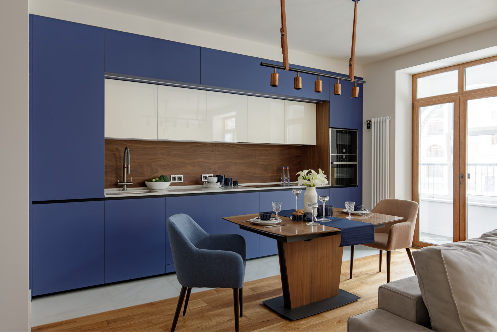 Inspiration for a medium sized contemporary single-wall kitchen/diner in Moscow with a single-bowl sink, blue cabinets, engineered stone countertops, brown splashback, wood splashback, integrated appliances, no island and white worktops.