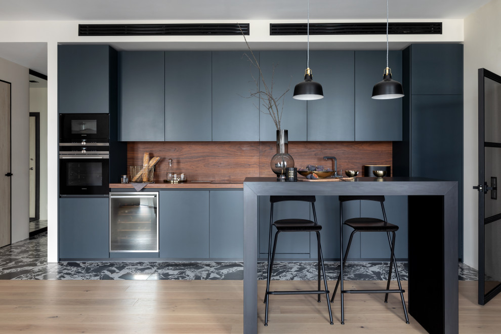 Inspiration för mellanstora moderna linjära brunt kök och matrum, med en enkel diskho, svarta skåp, träbänkskiva, brunt stänkskydd, stänkskydd i trä, integrerade vitvaror och en köksö