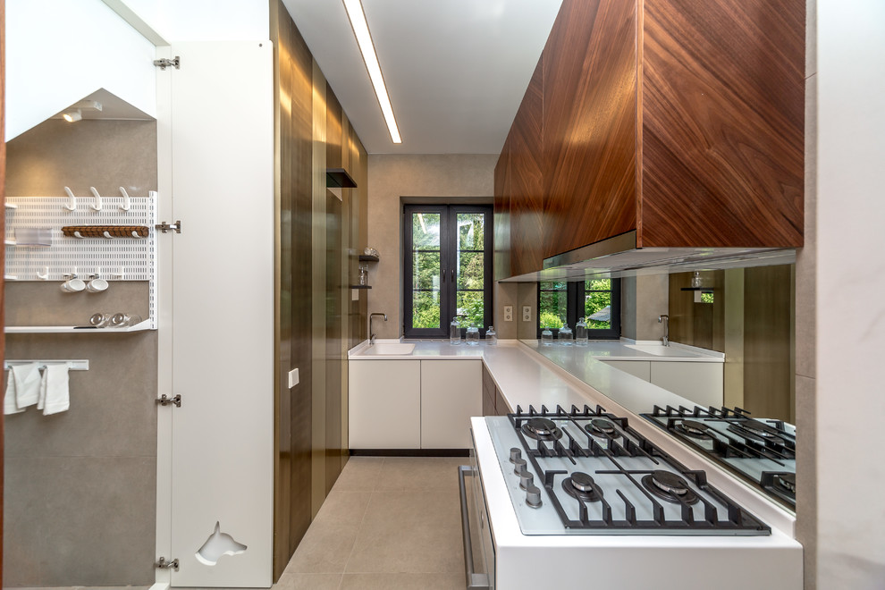 This is an example of a contemporary l-shaped enclosed kitchen in Moscow with an integrated sink, flat-panel cabinets, white cabinets, glass sheet splashback, porcelain flooring, no island and beige floors.